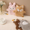 A collection of cute plush animals, including a pink bunny and a brown fox, displayed on a white surface.