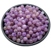 A pile of small, round purple acrylic beads for jewelry making.