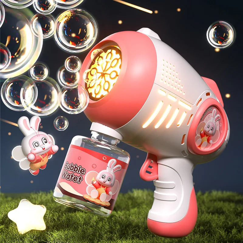A pink automatic bubble machine with lights is shown next to liquid soap and floating bubbles on green grass.