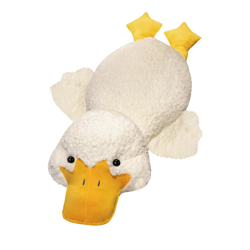 A white plush duck pillow with yellow accents, designed as a cuddly companion for lounging.