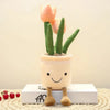 A cute succulent plant made of soft fabric resembling a tulip is potted in a white ceramic pot and stands on a wooden block.
