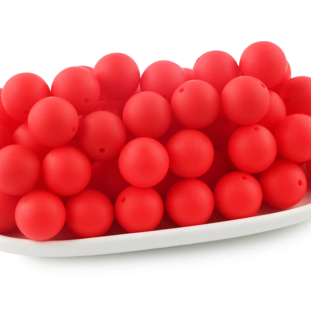 A pile of bright red round silicone beads for jewelry making and DIY crafts.