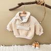 A beige toddler fleece-lined winter coat is displayed hanging on a wooden branch against a neutral background.
