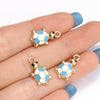Gold-toned enamel marine life charms featuring a white and blue turtle design