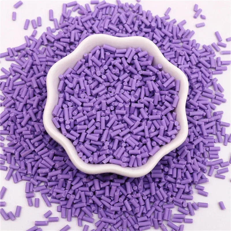Purple polymer clay slice sprinkles scattered on a white surface, with a central mound.