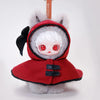 A red hooded plush doll with white hair and large red eyes, featuring a black bow and a metal keyring.