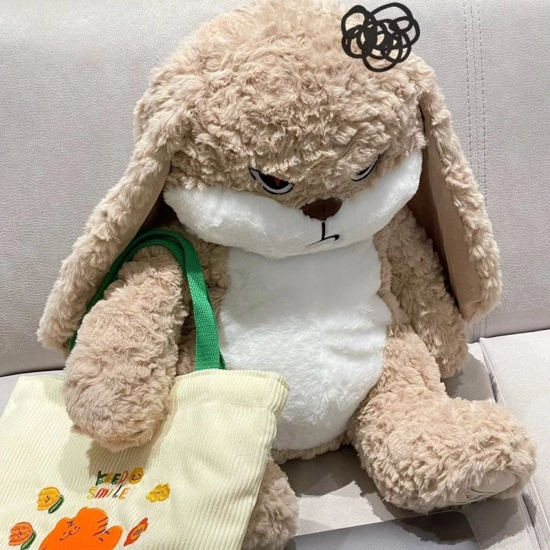 A fluffy brown rabbit plush doll with angry facial features sitting on a white surface.