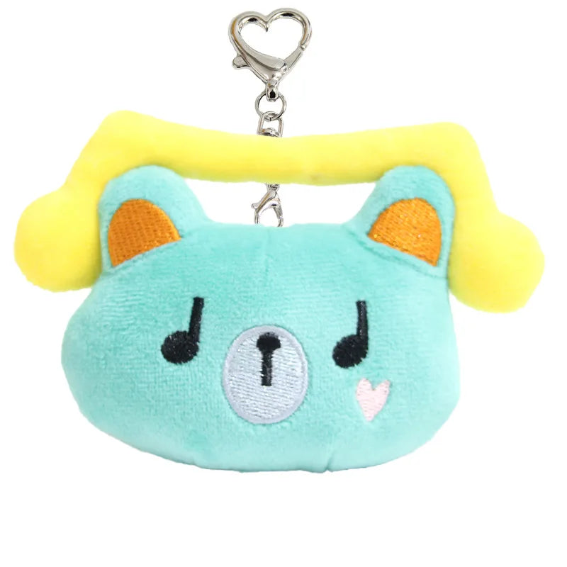 A light blue plush pendant doll shaped like a bear with yellow ears and a heart-shaped silver clip.