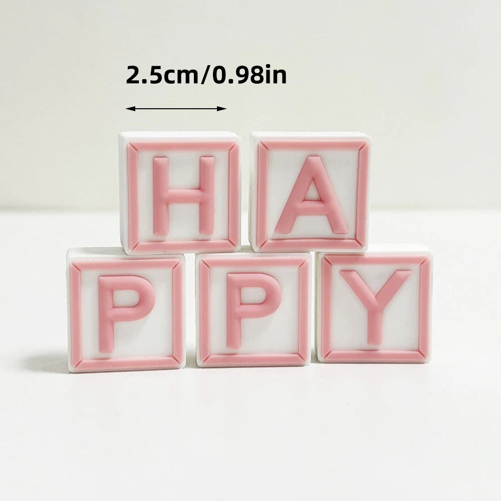 Pink acrylic letter blocks spelling HAPPY with a measurement guide.