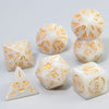 A set of white marble polyhedral dice featuring an ornate gold dragon pattern.