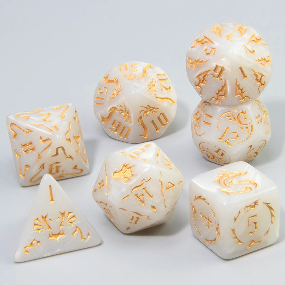 A set of white marble polyhedral dice featuring an ornate gold dragon pattern.