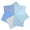 A stack of seven light blue and white patterned cotton fabric squares for quilting and patchwork.
