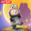 A gray collectible plush doll resembling a rabbit with large ears and an open mouth, set against a purple background.
