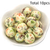 A bowl filled with ten natural-colored silicone beads featuring floral and leaf patterns for DIY jewelry making