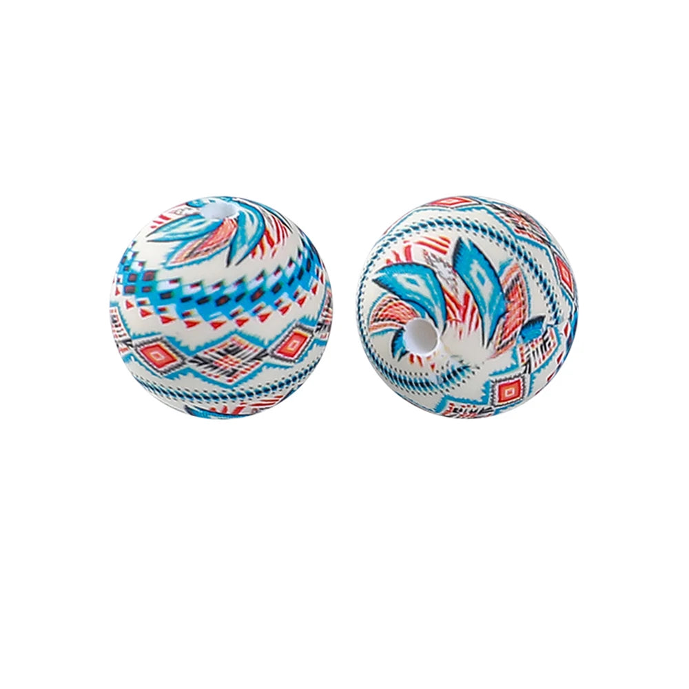 Two round silicone beads decorated with blue, white, and red geometric patterns for jewelry making