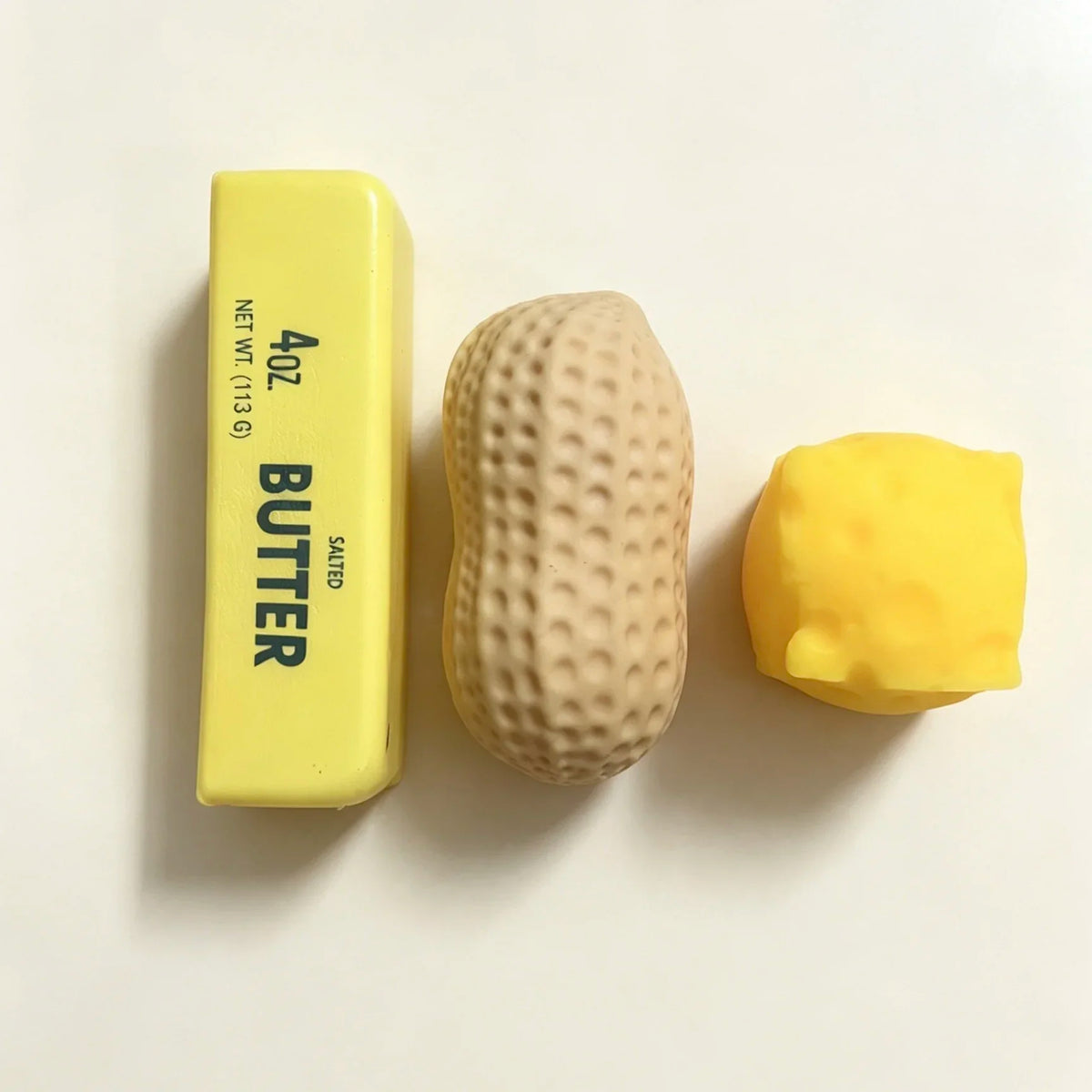 A yellow butter squeeze stress relief food-shaped squishy is shown next to its packaging.