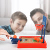 A close-up of a mini tabletop basketball game with orange balls and a blue hoop, being played by a child.