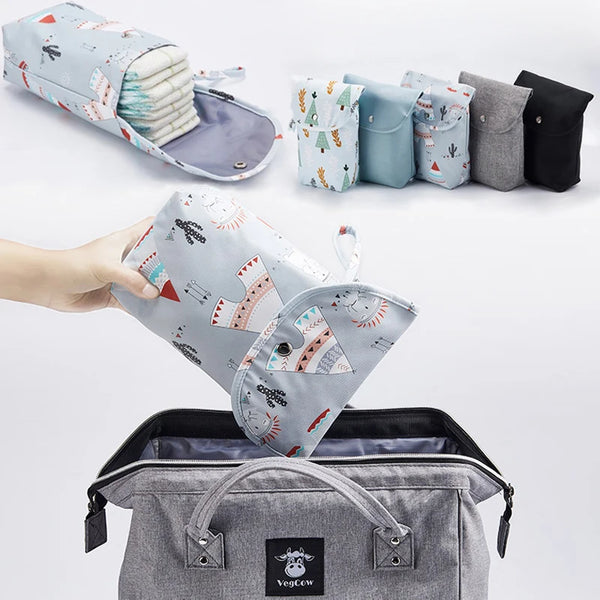 Eine Sammlung wasserdichter Windeltaschen-Organizer und Accessoires in verschiedenen Farben und Mustern, neben einem grauen E