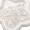A pile of multicolor glass beads in various sizes and opacities is displayed in a white mold.