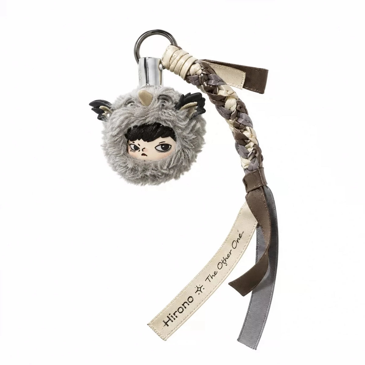 A keychain featuring a fuzzy gray face with black hair and a brown leather strap.