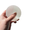 A hand is holding a translucent, oval-shaped strawberry mochi squishy stress relief toy.