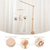 A wooden felt forest animal crib mobile hanging from a light fixture with a long wooden arm.
