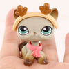 A small, light gray cat figure with tan ears and a pink scarf is held in a person's hand.