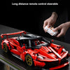 A red die-cast hypercar model is shown with a wireless remote control being held above it.