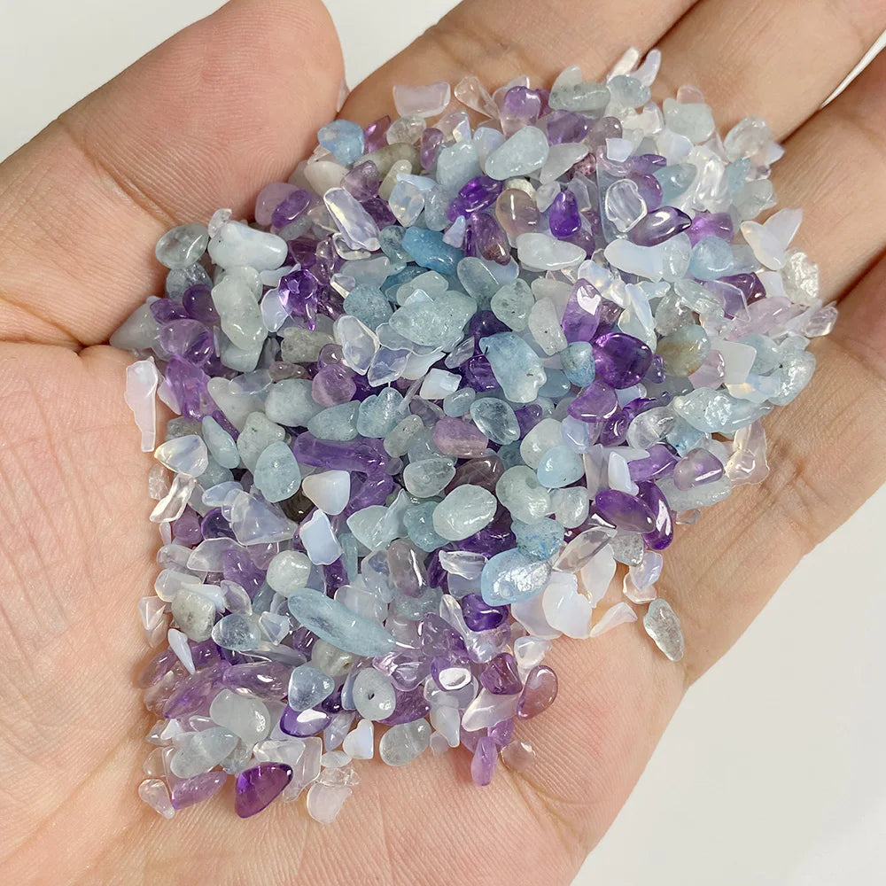 A handful of tumbled stone chips featuring shades of purple and blue quartz crystals.