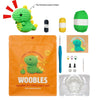 An orange bag containing a crochet kit for beginners, showing a finished green dinosaur toy and yarn.