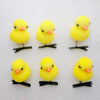 A set of six yellow duck plush hair clips with black wire bases
