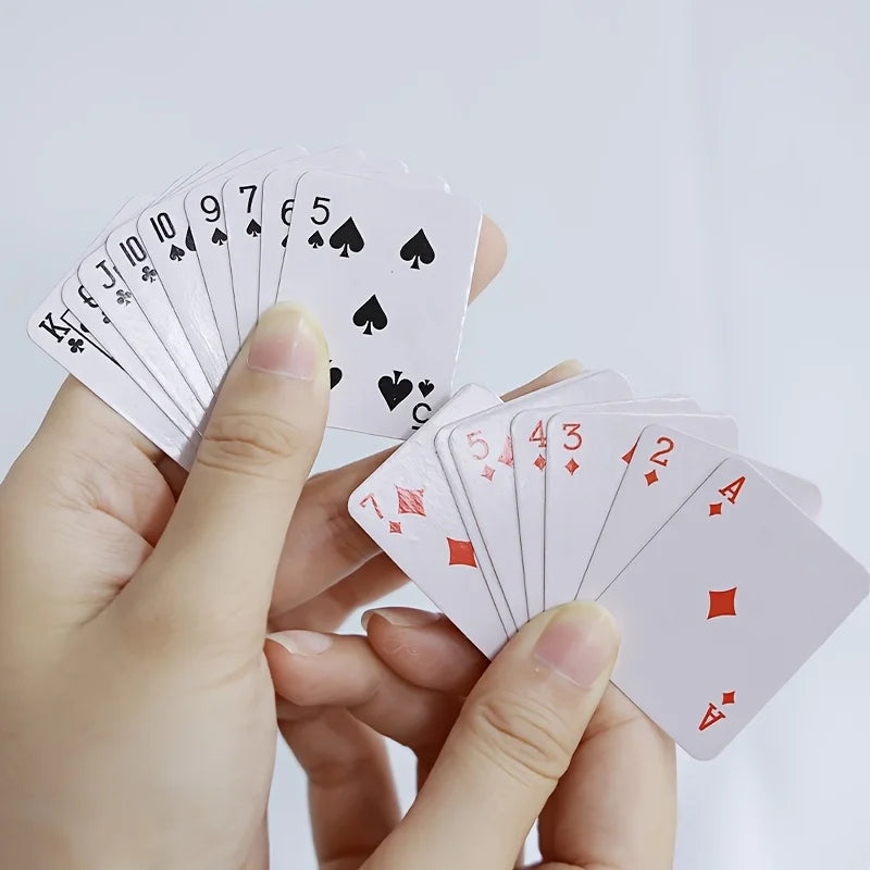 A hand is holding a fan of playing cards, including kings, tens, and aces.