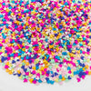 A pile of colorful polymer clay star and heart sprinkles in various bright colors.