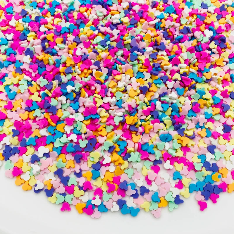 A pile of colorful polymer clay star and heart sprinkles in various bright colors.