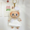A small rabbit doll wearing a white wedding dress outfit with floral accents and a gold key charm.