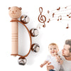 A wooden bear musical instrument set with a rod and metal balls is shown next to a baby.