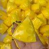 A hand holds a yellow, triangular cheese stress ball with a 7cm measurement, surrounded by other yellow pieces.