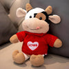 A red and white cow plush toy with floppy ears and a heart design on the chest.