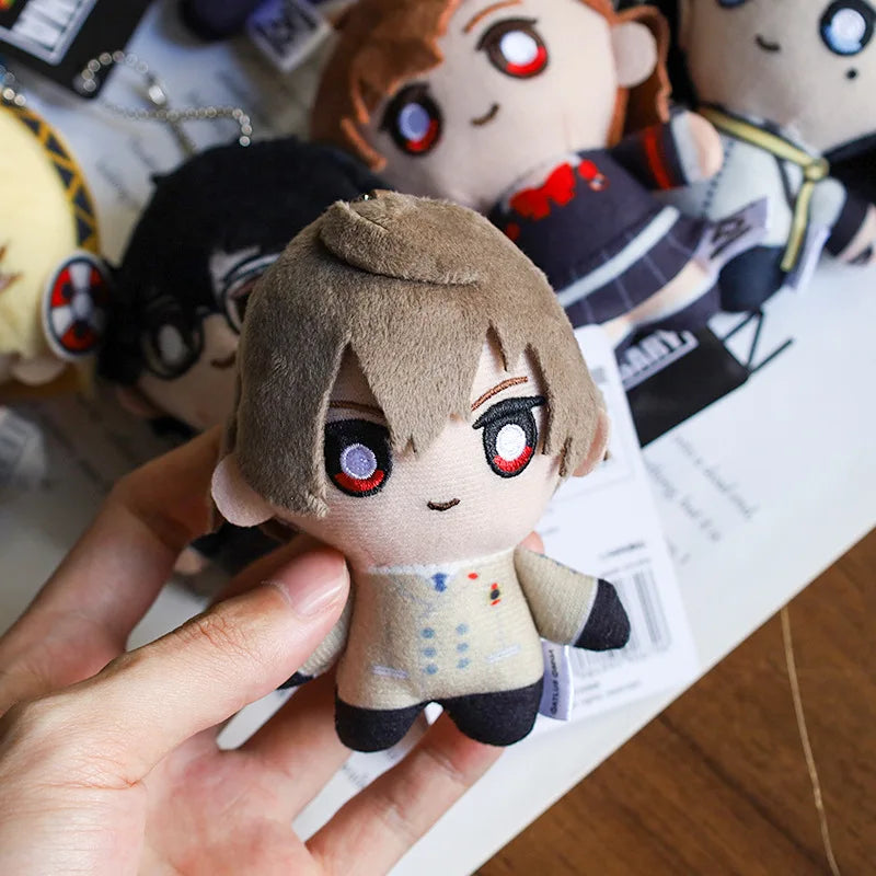 A hand holds a plushie character with light brown hair and red eyes, featuring detailed facial features and clothing.