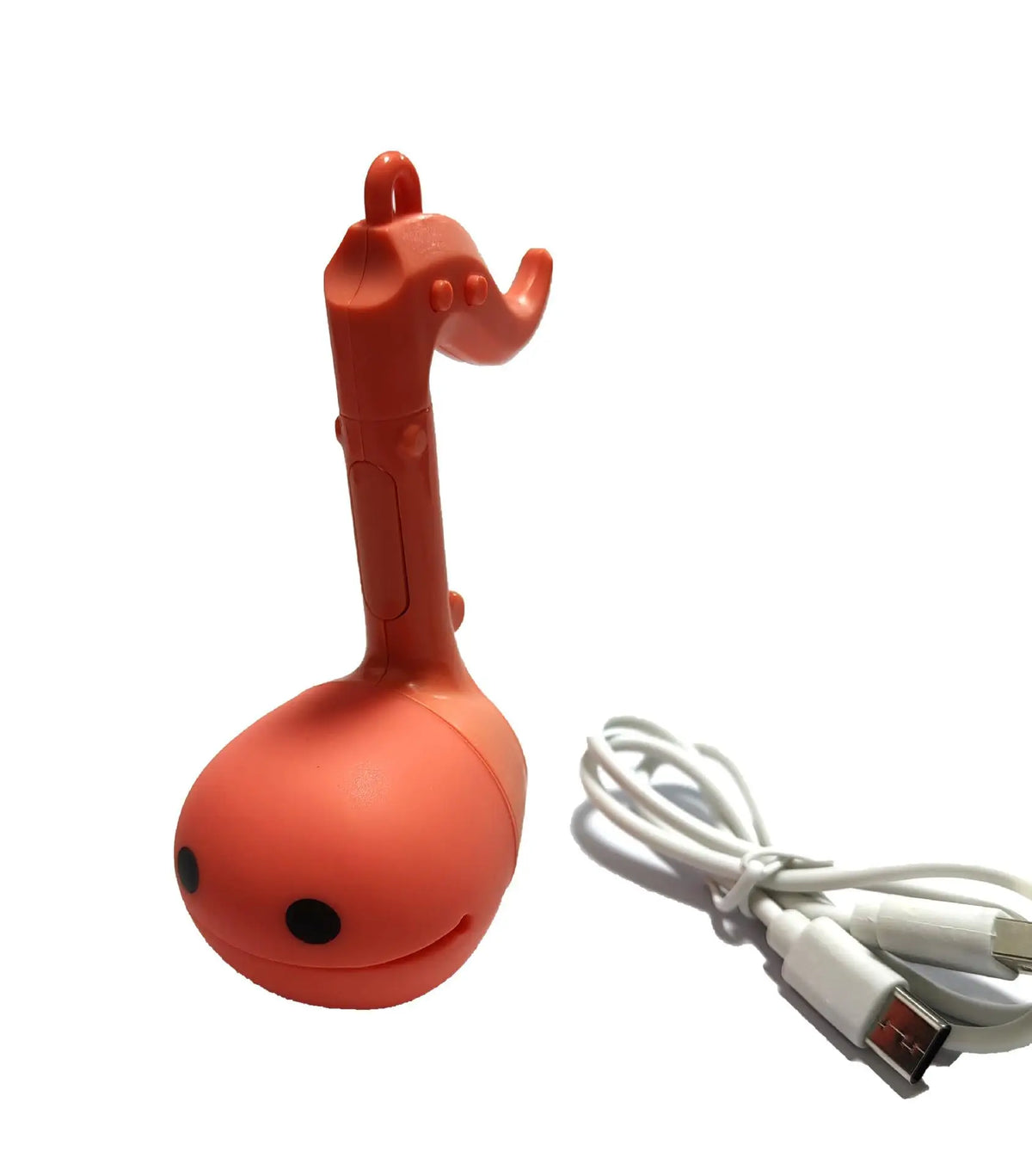 An orange Otamatone mini electronic musical instrument toy with a white cord.