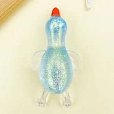 A bright blue, glittery duck squeeze toy with an orange beak is shown against a light background.
