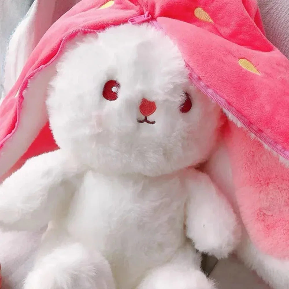 A white plush bunny toy with pink fabric draped over its head.