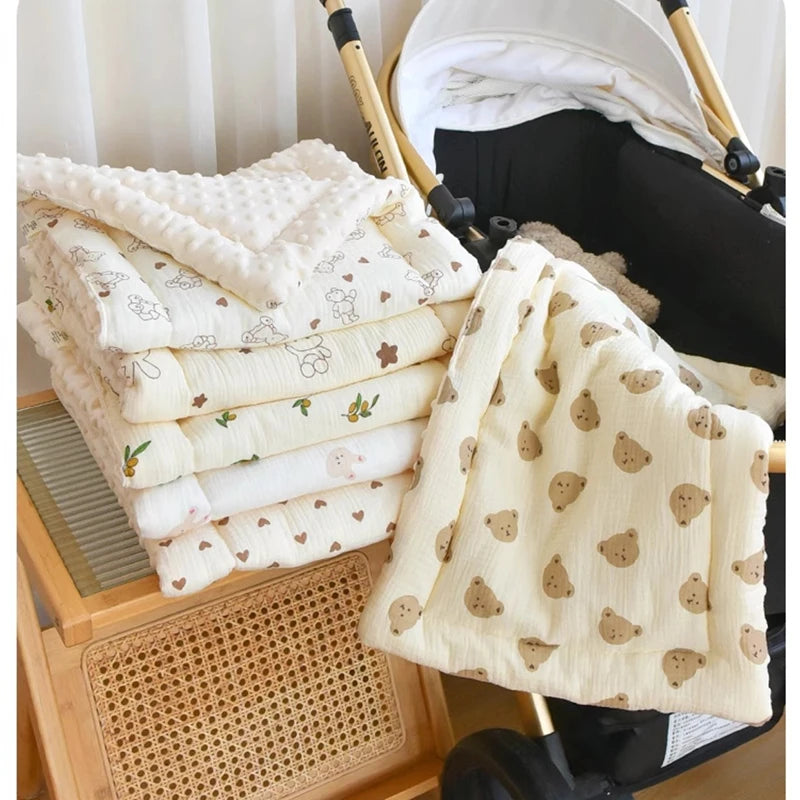 Une pile de matelas en coton blanc doux et une couverture jaune pâle à motifs pliée sont montrées à côté d'un siège auto noir