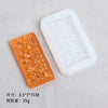 A rectangular orange silicone resin mold and a white plastic mold are shown on a gray surface.