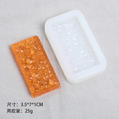 A rectangular orange silicone resin mold and a white plastic mold are shown on a gray surface.
