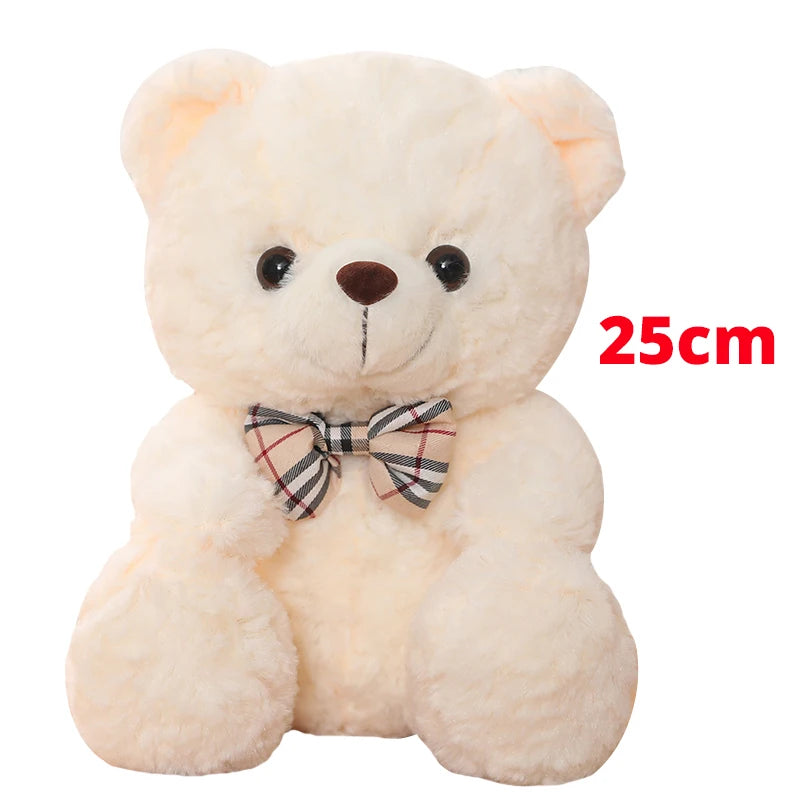 A soft, light beige teddy bear plush toy with a plaid bow, measuring 25cm.