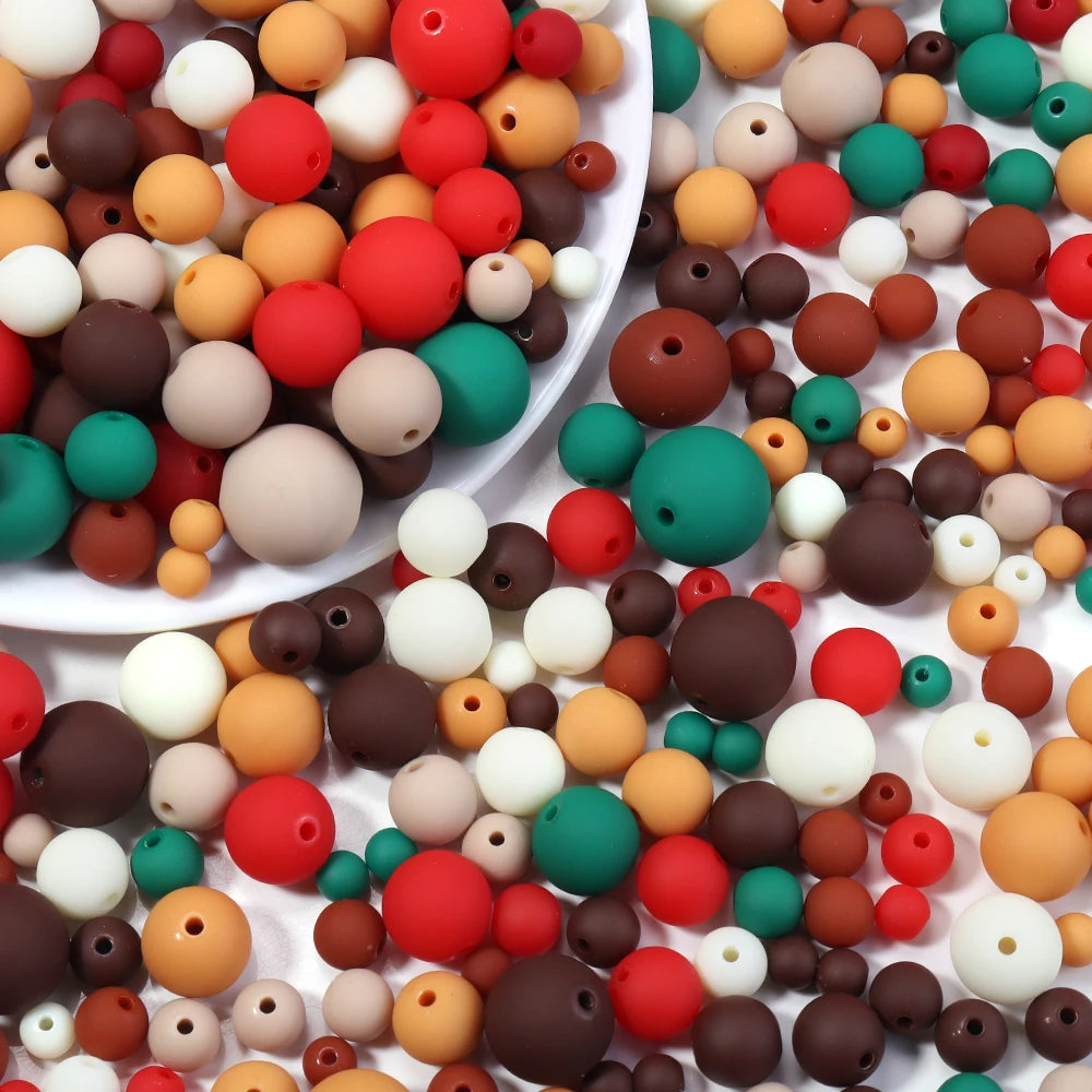 A collection of matte acrylic beads in various colors including red, orange, brown, white, and green.