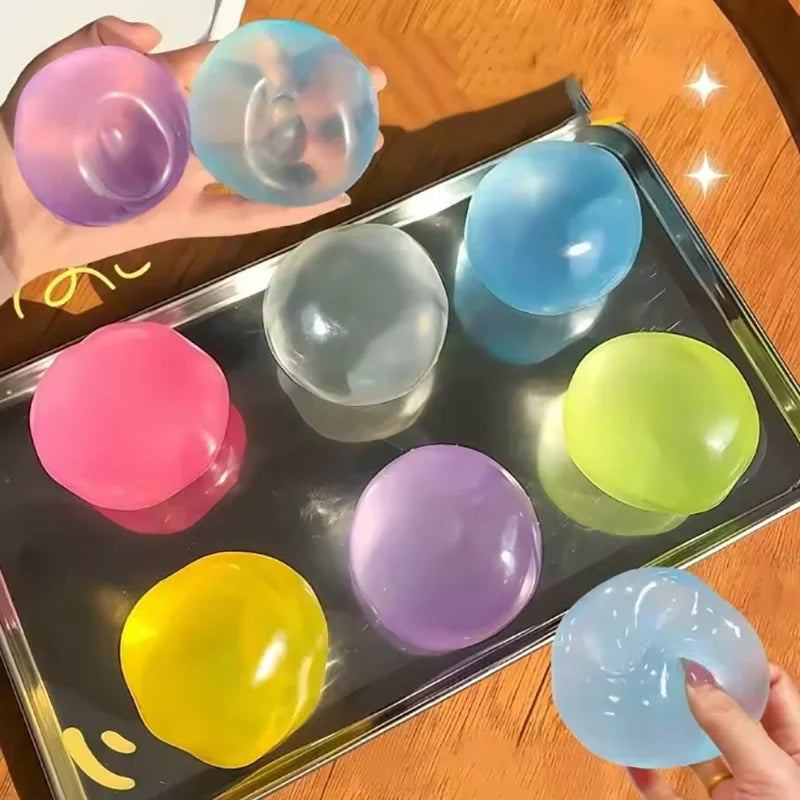 A collection of colorful squeezable soft fidget balls in various shades are displayed on a metal tray.