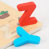 Two wooden alphabet puzzle pieces, a red Z and a blue Y, are shown on a light wooden surface.