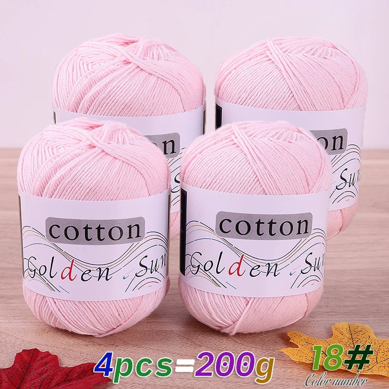 Four skeins of pink cotton knitting yarn labeled Golden Sun for crochet and handmade projects